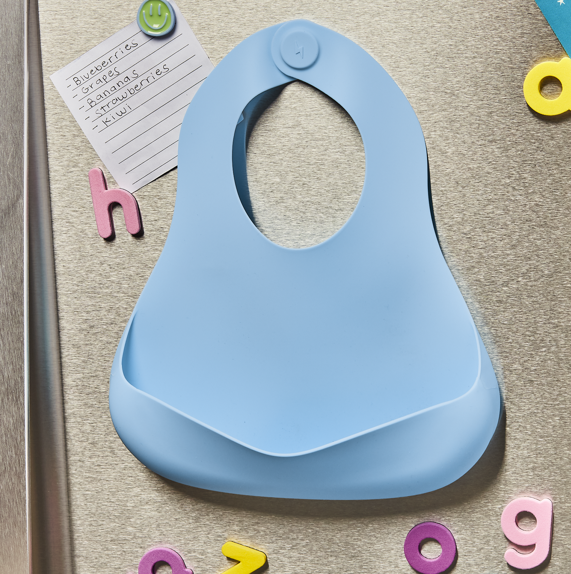 Babynetic Magnetic Silicone Bib storing flat on the refrigerator between meals